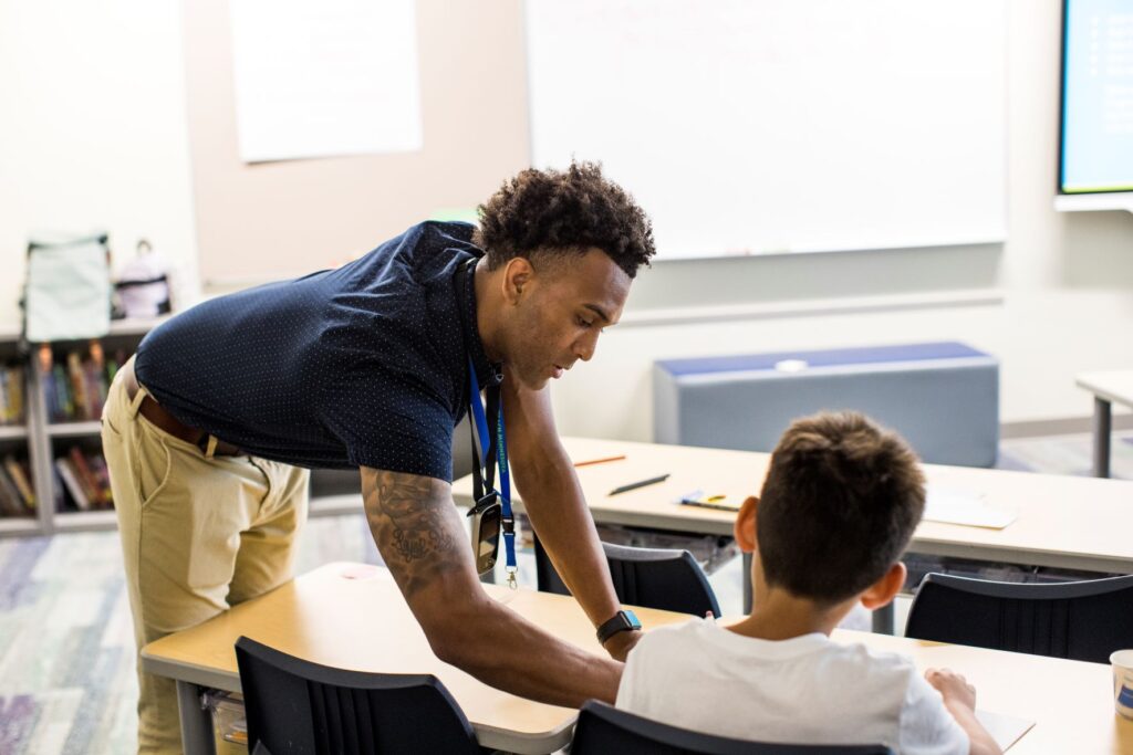 A teacher talking with his elementary school student