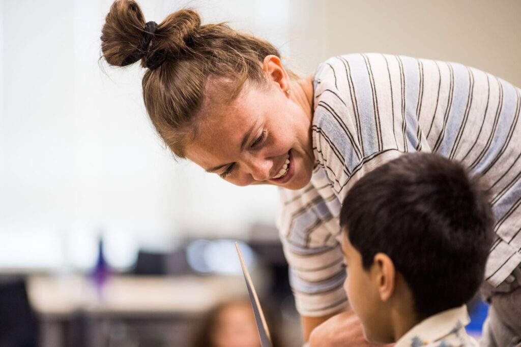 A teacher talking with her elementary school student